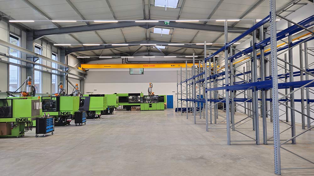 Innenansicht der Werkstatthalle mit Brückenkran und Regalen