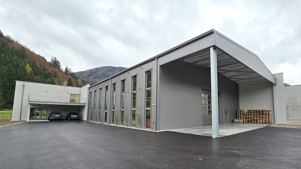 Fertighalle von Schwarzmann mit moderner isolierter Stahlkonstruktion und Vordach für Palettenlagerung