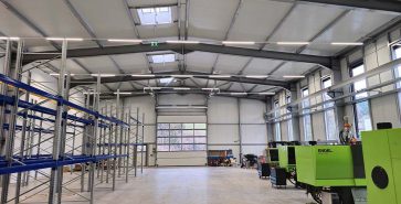 Produktionshalle mit Stahlkonstruktion, Regalsystemen und modernen Spritzgussmaschinen