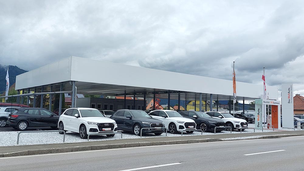 Schwarzmann X® Parkplatzüberdachung aus Stahl für Fahrzeuge bei einem Autohaus.