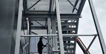 Bauteam montiert die Stahlkonstruktion einer neuen Industriehalle mit Hilfe von Hubarbeitsbühnen.