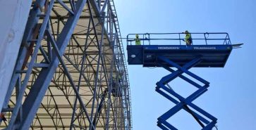Hubarbeitsbühnen im Inneren einer Industriehalle während abschließender Arbeiten an der Konstruktion.